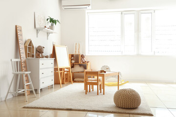 Interior of light playroom with toys and whiteboard in kindergarten