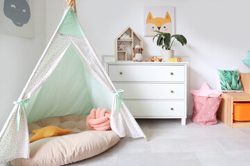 Interior of playroom with toys and teepee in kindergarten