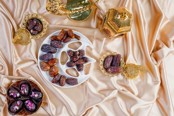 Ramadan kareem composition with various dates on golden fabric background.