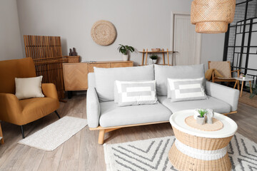 Interior of living room with sofa, armchair and wooden folding screen