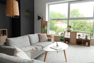 Cozy sofas, coffee table and shelving unit in interior of living room