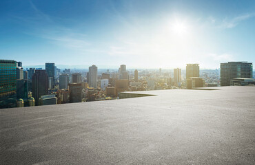 Rooftop balcony with a city backdrop under blue skies and sunshine.
