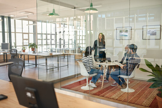 Businessman talking to colleagues sitting around a table in an office
