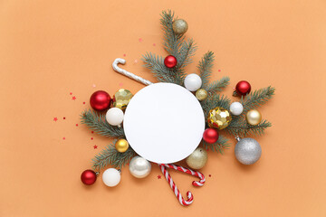 Blank card, Christmas balls, candy canes, confetti and fir branches on orange background