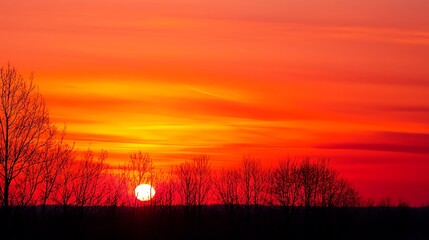 Obraz premium A sunset with a large orange sun in the sky