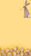 Small easter eggs and easter bunny isolated on solid yellow background