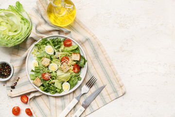 Plate with tasty Caesar salad, oil and bowl of peppercorn on white background