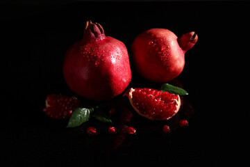 Tasty ripe pomegranates on black background