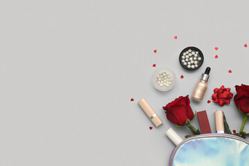 Cosmetic bag with makeup products and red roses on grey background. Valentine's day celebration