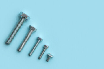 Row of different tap bolts on blue background