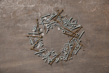 Different screws and chrome nuts on grey grunge background