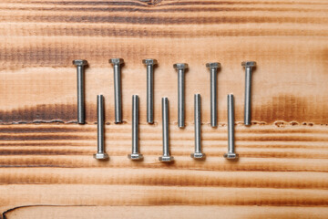 Tap bolts on brown wooden background