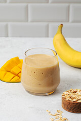 Tropical smoothie with mango, banana, and oats - healthy breakfast concept