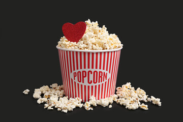 Bucket of popcorn with heart on black background. Valentine's Day celebration