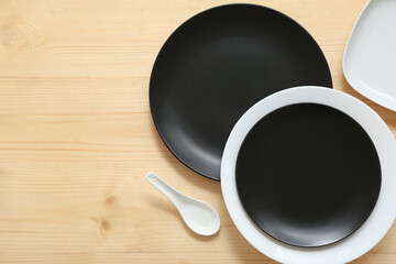 Table setting in white and black colors on wooden background