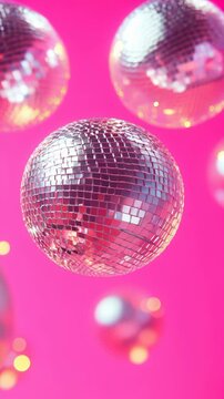 Glimmering disco balls reflecting vibrant colors against a bright pink background create a festive atmosphere perfect for a lively celebration. Ideal for Social Media, Stories, Advertising