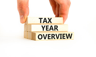 Tax year overview symbol. Concept words Tax year overview on beautiful wooden blocks. Beautiful white table white background. Businessman hand. Business tax year overview concept. Copy space.