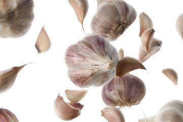 Flying fresh garlic and cloves on white background