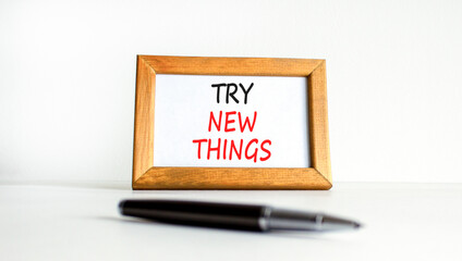 Try new things symbol. Concept words Try new things on beautiful wooden picture frame. Black pen. Beautiful white background. Business motivational lifestyle try new things concept. Copy space.