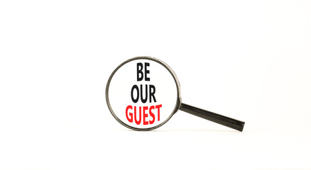 Be our guest symbol. Concept words Be our guest on beautiful white paper in magnifying glass. Beautiful white paper background. Business and be our guest concept. Copy space.