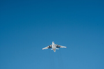 There is an aircraft, specifically a plane, navigating through the vast, clear expanse of the blue sky during daylight hours, showcasing the beauty of air travel in aviation