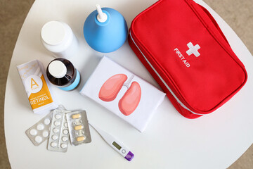 First aid kit with medical supplies on table in room. Top view