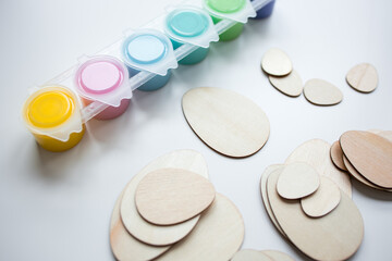 Assorted paints and wooden egg shapes for creative arts and crafts projects