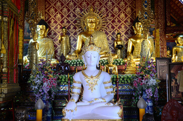 Fototapeta premium Ancient buddha in antique ubosot of Wat Phra Singh or Phra Sing temple for thai people traveler visit respect praying blessing wish myth holy mystical worship at Chiangrai city in Chiang Rai, Thailand