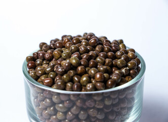 Closeup shot of Organic Black Peas in a Glass Bowl isolated on a white background. Black-eyed peas also called parched peas or dapple peas or Kala Vatana Desi Black Peas.