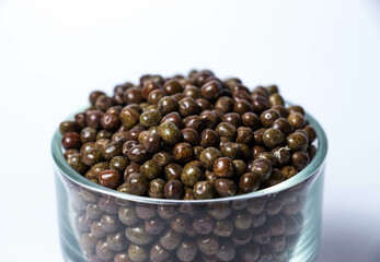 Closeup shot of Organic Black Peas in a Glass Bowl isolated on a white background. Black-eyed peas also called parched peas or dapple peas or Kala Vatana Desi Black Peas.