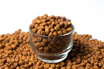 Horizontal shot of Organic Brown Chickpeas in a Glass Bowl Isolated on a white background. Black chickpeas, also known as kala chana, Bengal gram,Egyptian pea.