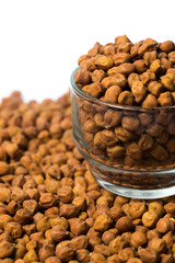 Vertical shot of Organic Brown Chickpeas in a Glass Bowl Isolated on a white background. Black chickpeas, also known as kala chana, Bengal gram,Egyptian pea.