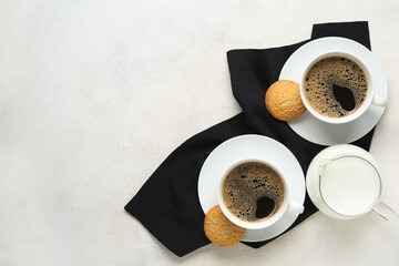 Cups of hot coffee with sweet cookies and jug of fresh milk on white background