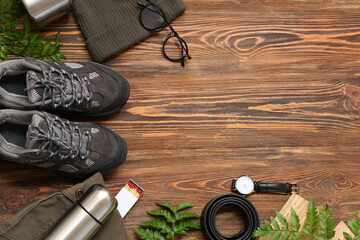 Composition with shoes, clothes, items for travel and fern leaves on wooden background