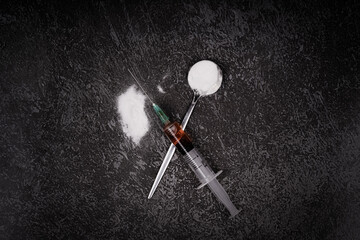 Syringe with drugs dose on black background. Narcotic substances in spoon. Drugs concept on dark...