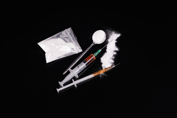 Syringe with drugs dose on black background. Narcotic substances in spoon. powder in plastic bag....
