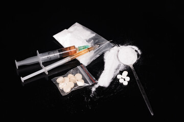 Syringe with drugs dose on black background. Narcotic substances in spoon. powder in plastic bag....