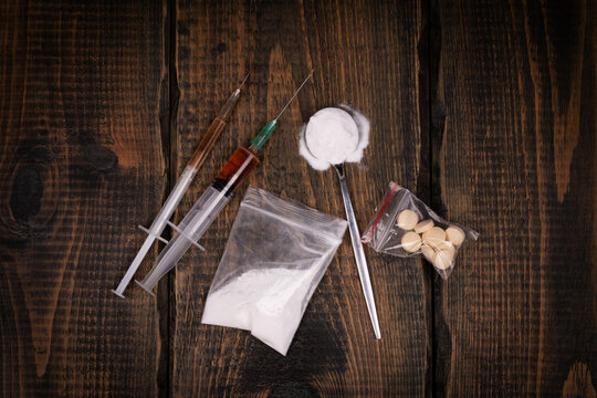 Syringe with drugs dose on black background. Narcotic substances in spoon. powder in plastic bag. Drugs concept on dark place. Heroin narcotic crime. Danger addict problem criminal