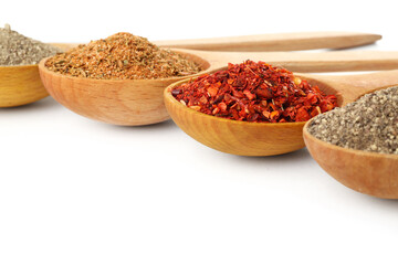 Wooden spoons with different spices on white background, closeup