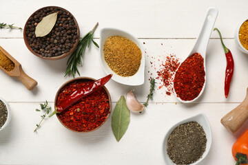 Composition with aromatic spices and herbs on light wooden background