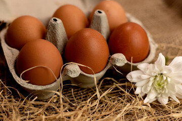 Organic brown eggs in an egg carton. Eggs in a box on straw. Broken Egg