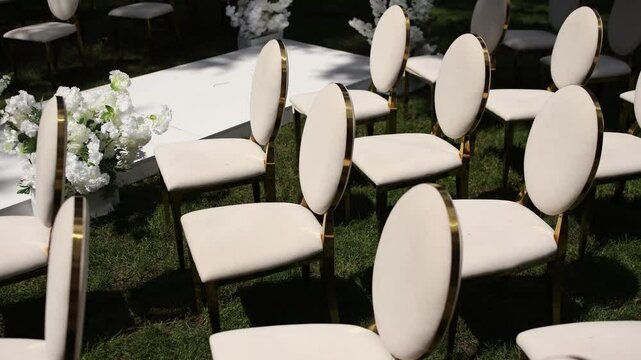 white chairs for a wedding ceremony with decor