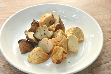 slice grilled king oyster mushroom or Enoki dressing salt and black pepper on plate