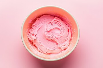 A bowl containing a delicious looking pink frosting mixture