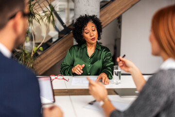 Professional Business Meeting Discussion with Documents in Modern Office Environment