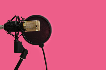 Stand with professional microphone on pink background