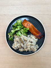 A plate of salmon, broccoli, and rice.