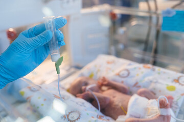 Nurse feeding premature baby via tube in neonatal intensive care