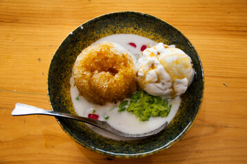 Local traditional thai dessert sweet meal and snack shaved ice with coconut ice cream on ceramic bowl serve for thai people customer eat drink on table at restaurant cafe shop in Chiang Rai, Thailand