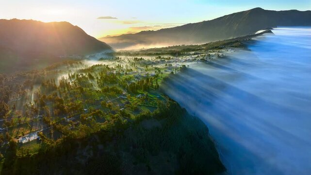 Aerial view flying to mount Bromo at sunrise, active volcano above sea of clouds, Java, Indonesia 
